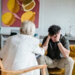 Therapist engages with a young man during a counseling session in a modern office setting.