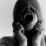 Visage d'une personne qui cri avec un bonnet tiré sur ces yeux; Théorie polyvagale TPV Françoise BOYER Psychopraticienne relationnelle